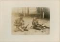 Men making a head rest and a sago mallet