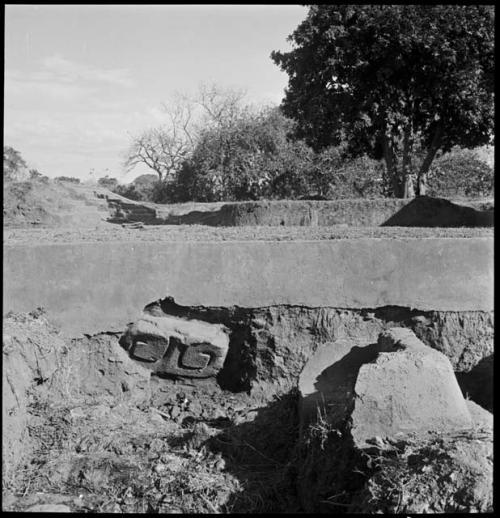 Carved stone, in situ in W. wall of structure, just E. of steps. looking E