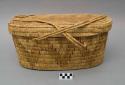 Oblong utility basket, coiled. With lid and handle. Made of bear grass.