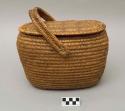 Oval utility basket, coiled. Lid and handle. Made of bear grass.