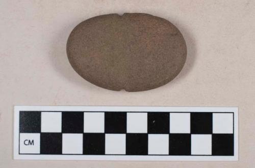 Ground stone, notched on both sides, possible weight