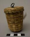 Small covered sweetgrass basket with green-dyed splints; glass jigger inside