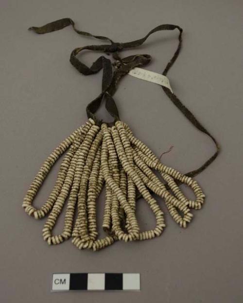 Baby's apron of ostrich beads on sinew cords with leather thongs