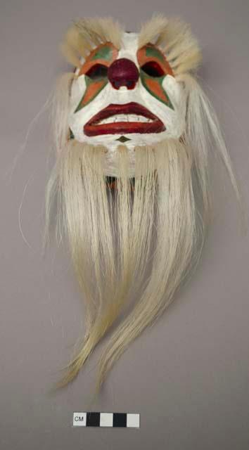 Wooden mask painted like a clown, long beard