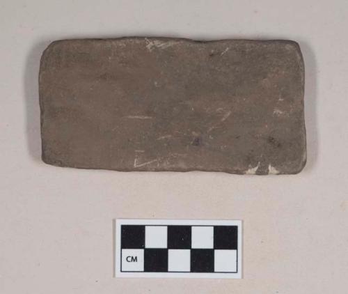 Ground stone, flat rectangular stone fragment with rounded corners