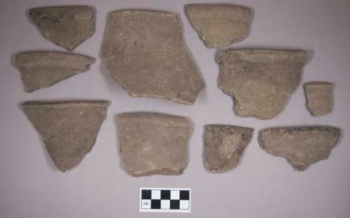 Ceramic, earthenware rim, body, and handle sherds, undecorated, one incised, shell-tempered; two sherds crossmend