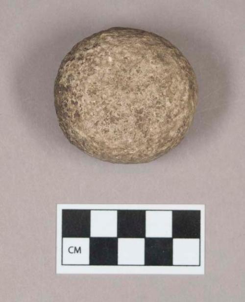 Ground stone, pecked and ground stone disc, pitted on both sides