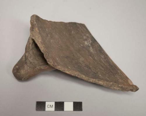 Large potsherd from red-brown tripod bowl with one foot