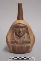 Straight spouted vessel depicting shaman woman with long shawl