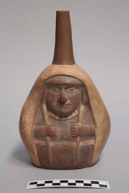 Straight spouted vessel depicting shaman woman with long shawl