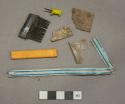 Plastic fragments, 1 black comb fragment, 1 tan bandage fragment, 1 white and blue straw, 1 yellow plastic fragment, 1 colorless clear cellophane fragment, 1 intact yellow push pin