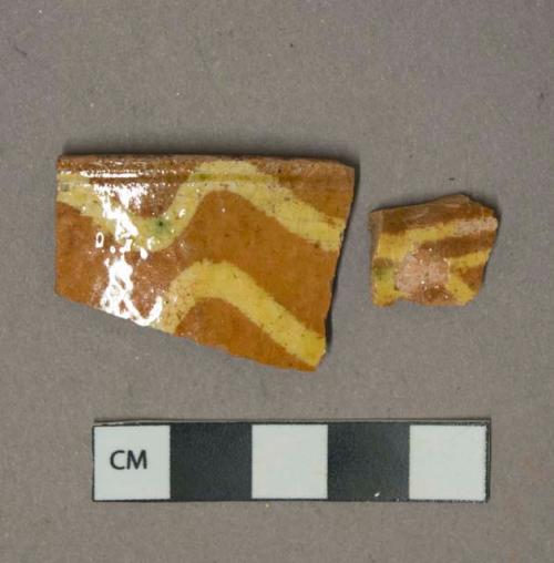 Yellow on red slip decorated redware vessel body and rim fragments