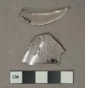 Colorless glass vessel fragments, 1 rim fragment, 1 body fragment with embossed lettering including "[...]EAL S[...]"