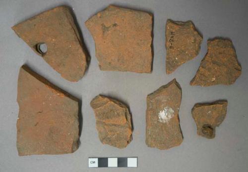 Red ceramic rooftile fragments, 1 with fingerprint, 1 with nail hole