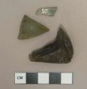Dark olive green glass vessel fragments, weathered