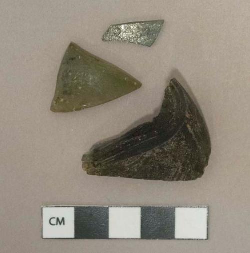 Dark olive green glass vessel fragments, weathered