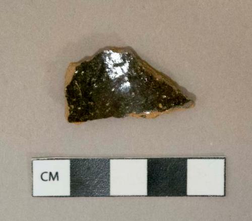 Dark brown lead glazed redware vessel body fragment, visible temper