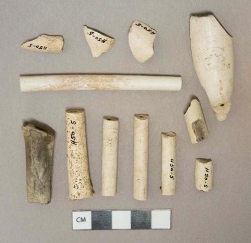 White kaolin pipe stem and bowl fragments, 1 stem with molded decoration, 1 bowl with "T.D." cartouche stamp,  2 stem fragments with 4/64" bore diameter, 2 stem fragments with 5/64" bore diameter, 1 stem fragment with 6/64" bore diameter, 1 stem fragment with 7/64" bore diameter, 1 stem fragment with 8/64" bore diameter.