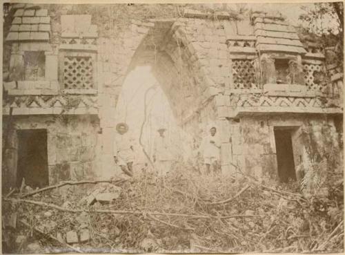 Three men standing under Arch, view from west side