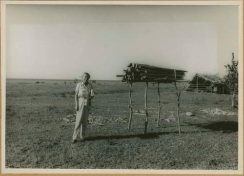 EBL (possibly Eleanor B. Lothrop) standing next to balsa logs before Balseria Ceremony