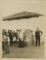 Group in front of a building, with man wearing mask