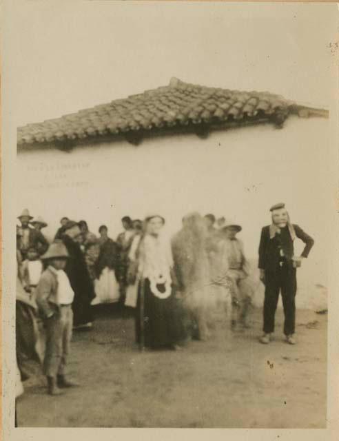 Group in front of a building, with man wearing mask