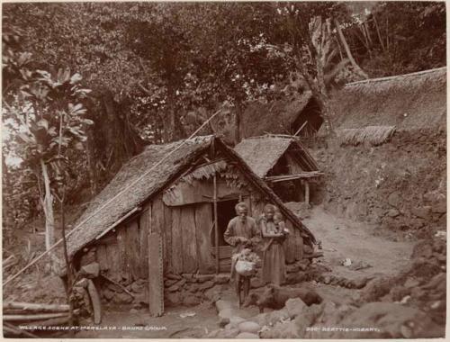 Man, woman and child in front of house