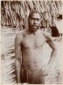 Man standing in front of thatched structure