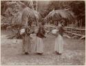 Three women carrying yams in baskets
