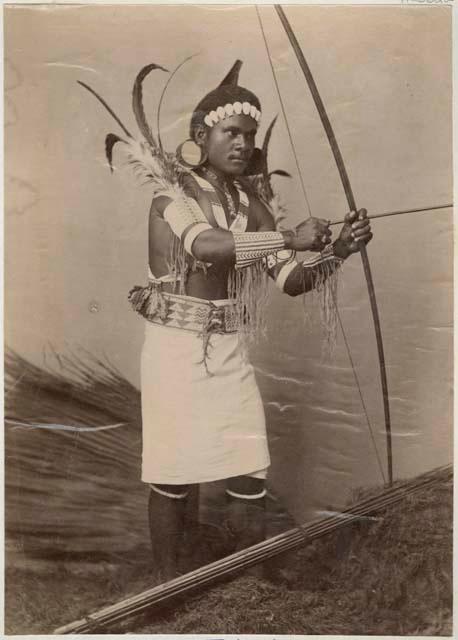 Studio portrait of a man with bow and arrow