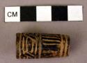 Incised black clay bead ca. 3 cm long