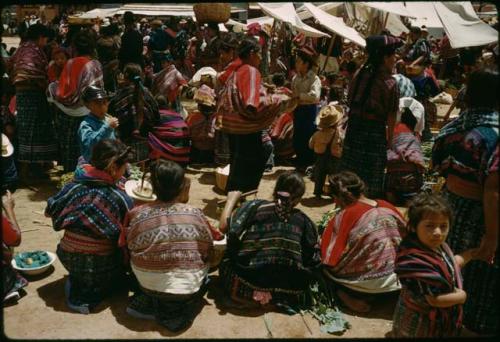 Comalapa, view of women's huipiles, red across shoulder with stripe