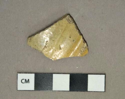 Tan lead glazed earthenware vessel body fragment, buff paste, likely North Devon slipware