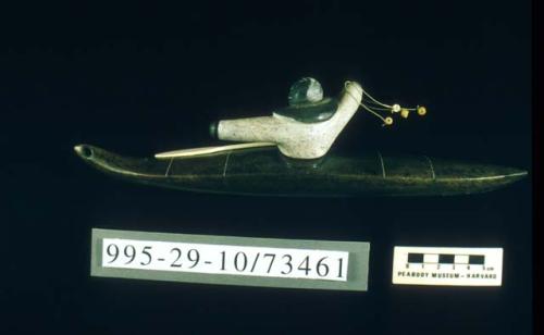 Soapstone carving of man in kayak with bola and ivory paddle