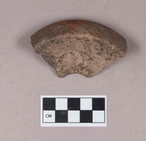 Ground stone, discoidal stone fragment, concave on both sides, perforated in the center