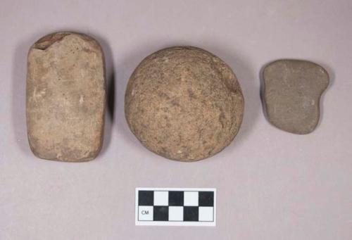 Ground stone, round stone, possible pounding stone; ground stone, worked rectangular stone; flat stone, likely non-cultural