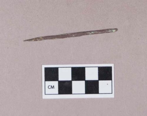 Copper alloy object, likely pin, cylindrical, pointed at one end