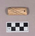 Cut and worked animal bone tube, two perforations at one end, incised linear decoration, less deeply incised design on one side