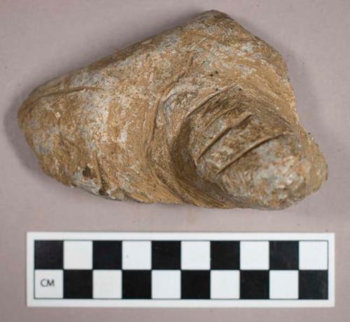 Ground stone, steatite vessel base fragment with foot and multiple incisions