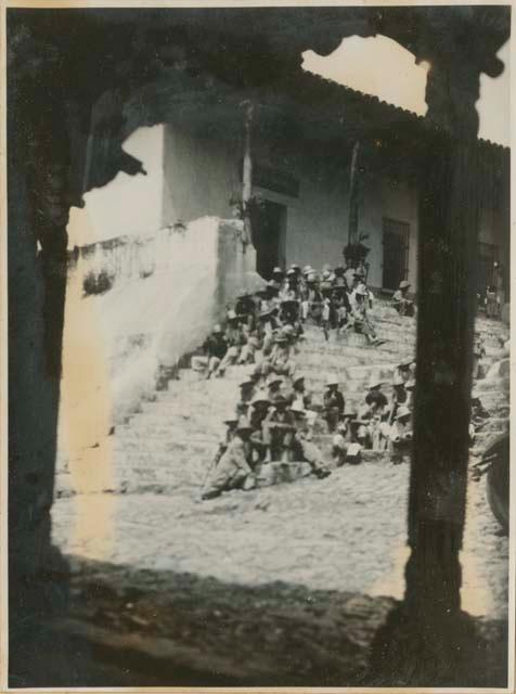 Group of men sitting on steps of building