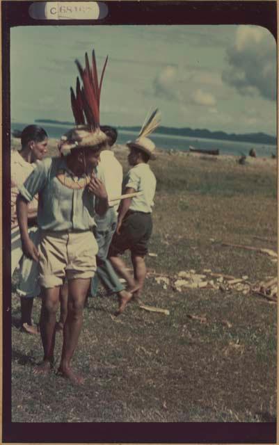 Ngobe-Bugle men in feathered hats at mouth of the Cricamola River holding sharpened balsa poles during Balseria