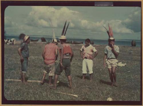 Ngobe-Bugle crowd next to Cricamola River, men in feathered hats with balsa poles on ground