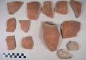 Earthenware vessel body and base sherds with red paint exterior decoration