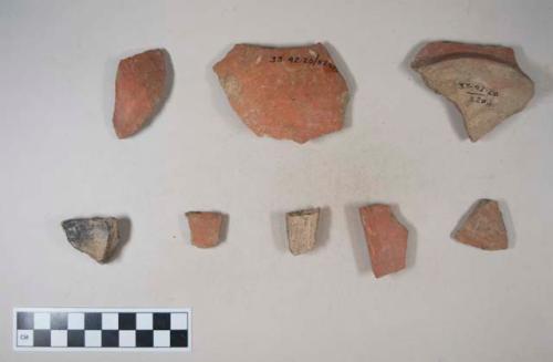 Earthenware vessel sherds with red paint decoration; base, body, and rim sherds