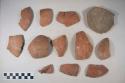 Earthenware vessel sherds with red paint exterior decoration, buff interior; Base and body sherds.