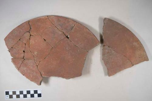 Earthenware plate sherds with red paint decoration; some sherds of an earthenware vessel with red paint exterior; other sherds with polychrome decoration. Some base, body, and rim sherds.