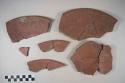 Earthenware vessel sherds with red paint interior; probably plate with ring foot base.