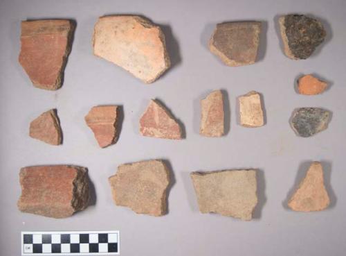 Earthenware vessel sherds; red paint exterior decoration; Base, rim, and body sherds.