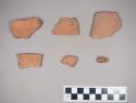 Restored section (& 3 sherds) of a red sandy ware dish which shows traces of red