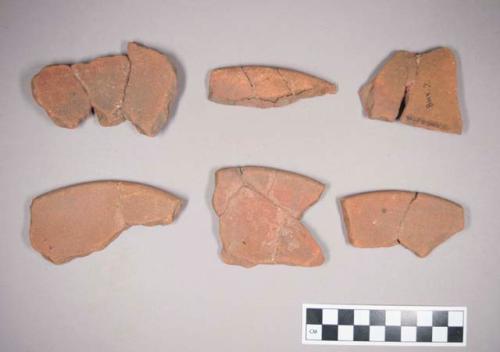 9 fragments of sandy hard red ware bowl with traces of red paint on inside